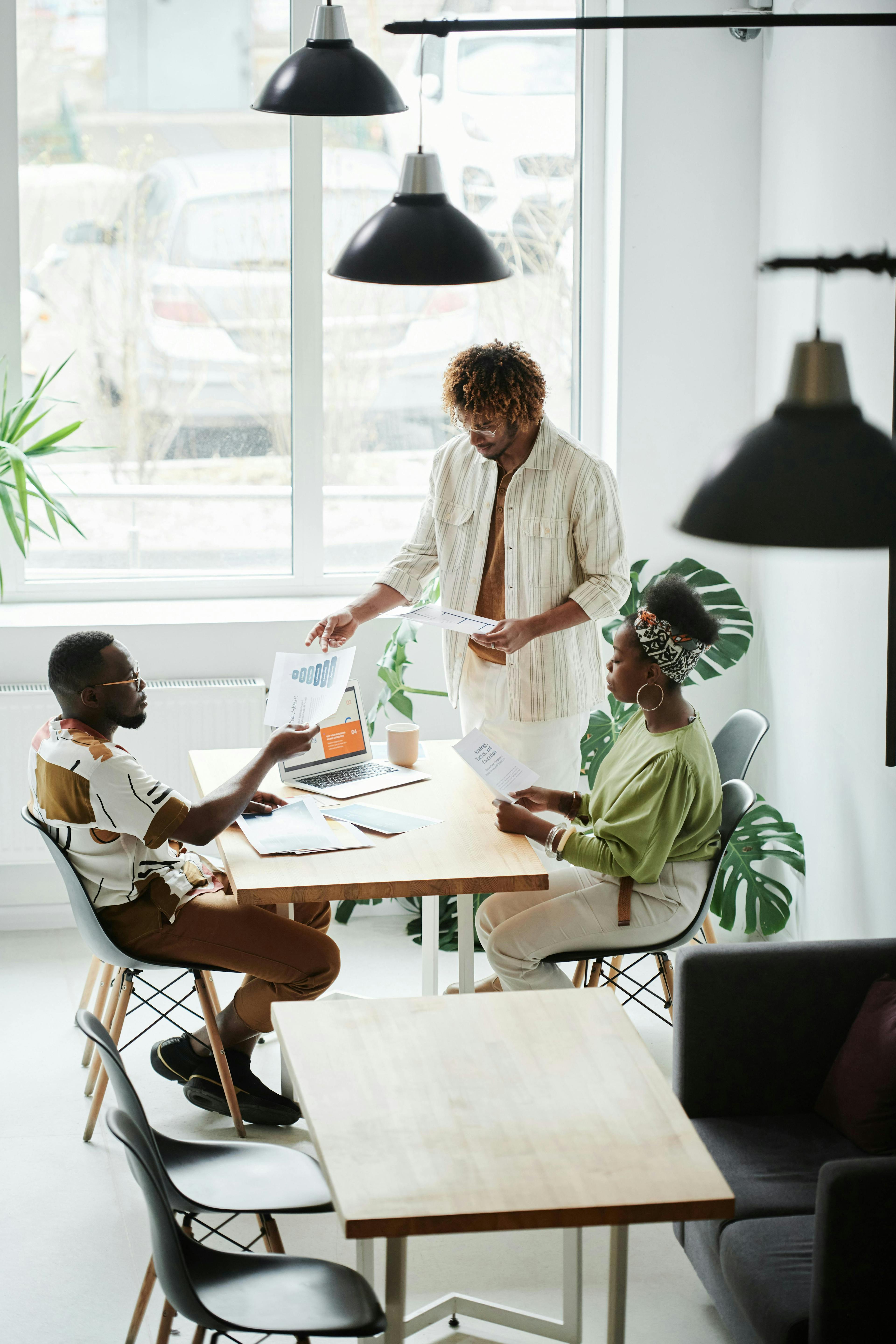 three individuals collaborating in a modern office setting, reviewing documents, and discussing strategies. This scene effectively captures the teamwork involved in leveraging "lead generation services" to drive business growth and success.