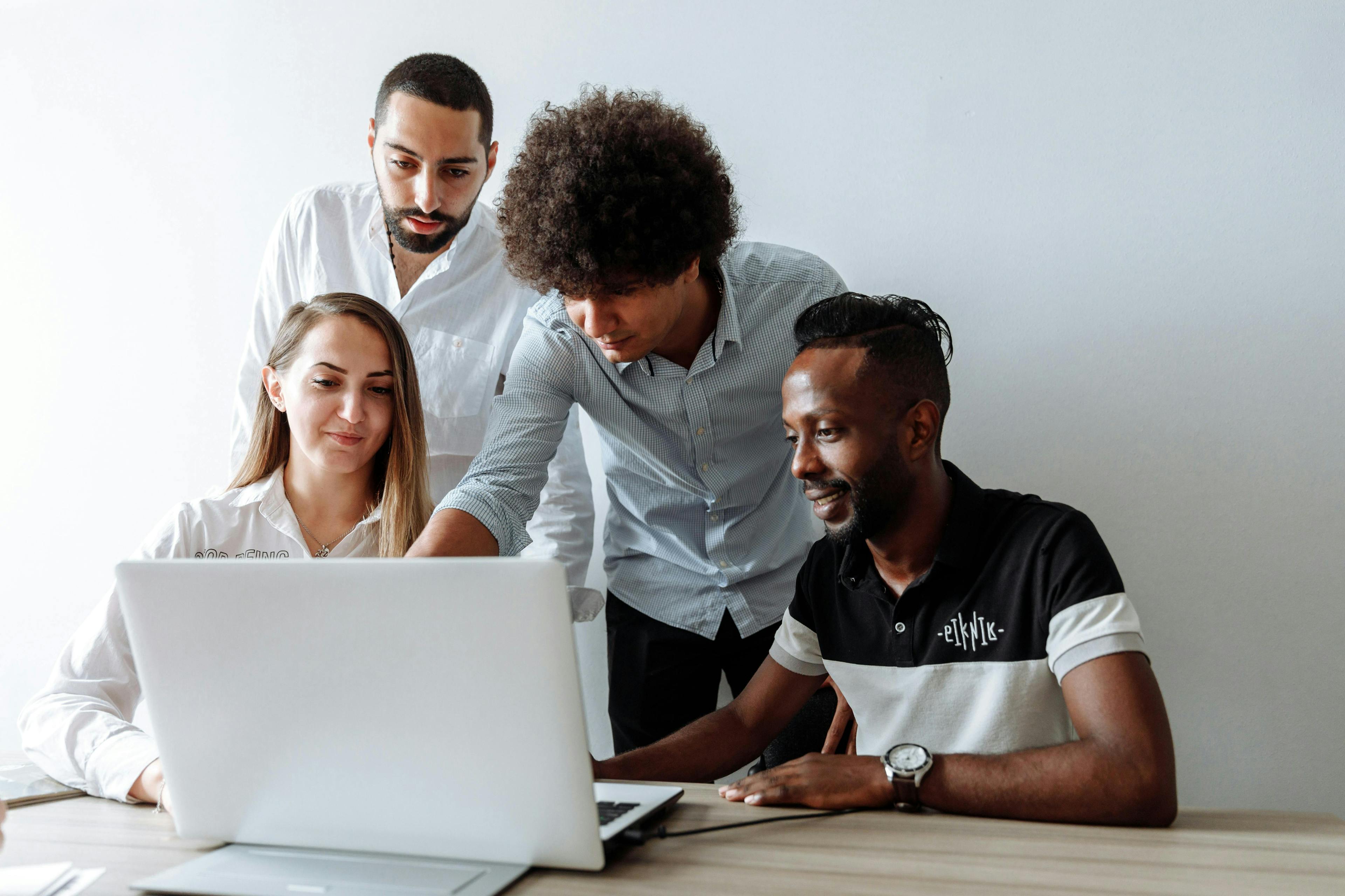 A team collaborating on a project while gathered around a laptop. This image can inspire lead magnet ideas for business teamwork and productivity.