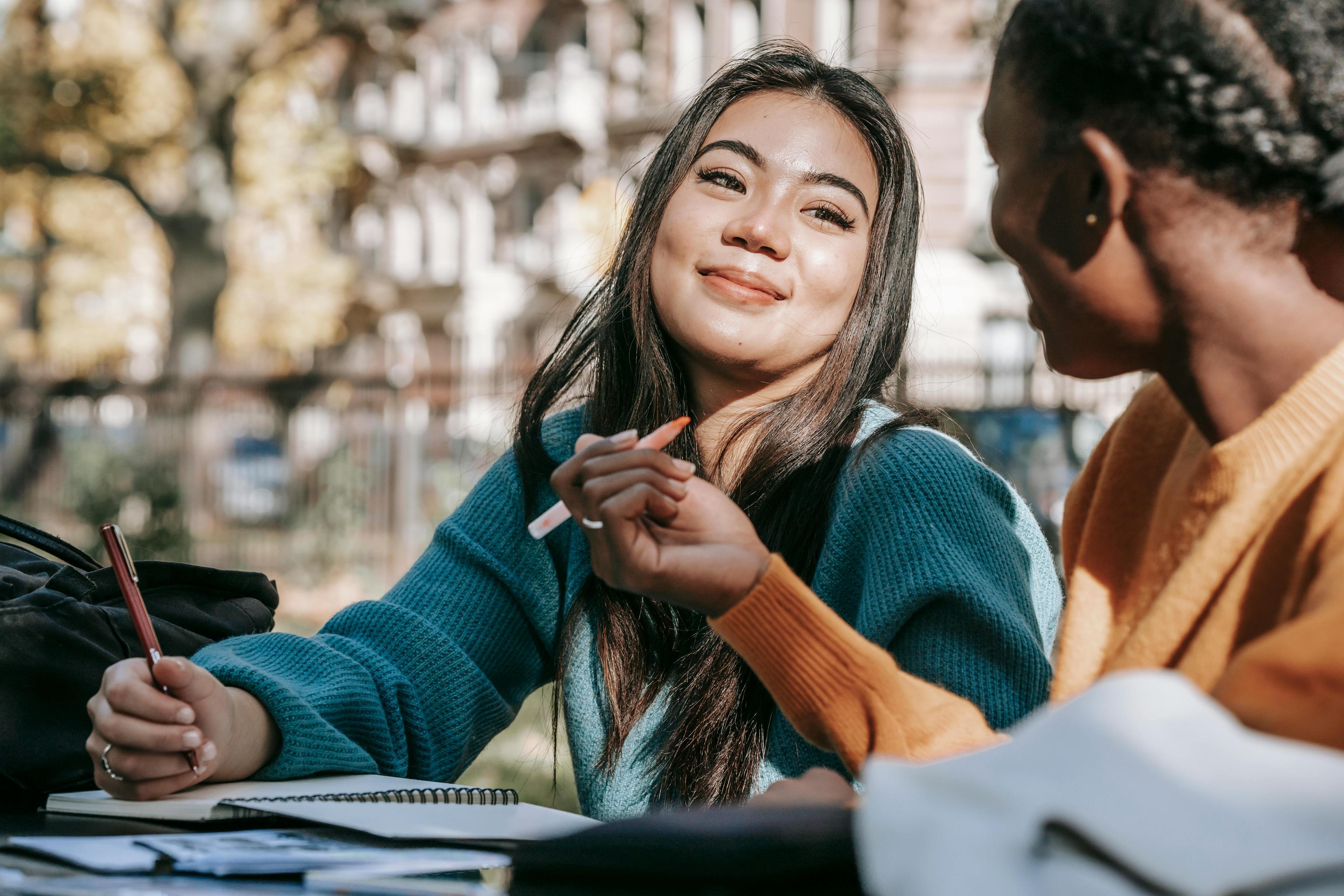 A candid shot of two people in conversation, one smiling warmly, set outdoors. This serene moment highlights collaboration, perfect for showcasing van track custom conversions that foster connectivity on the go.