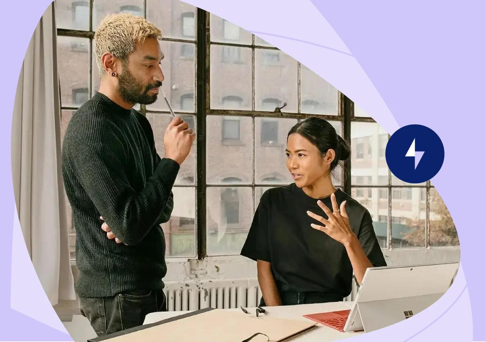 Two colleagues engaged in a discussion in a bright office space, with a tablet on the table in front of them. The woman is gesturing while the man listens thoughtfully, creating a collaborative atmosphere. This scene could represent teamwork in utilizing the best AI image generator for creative projects.