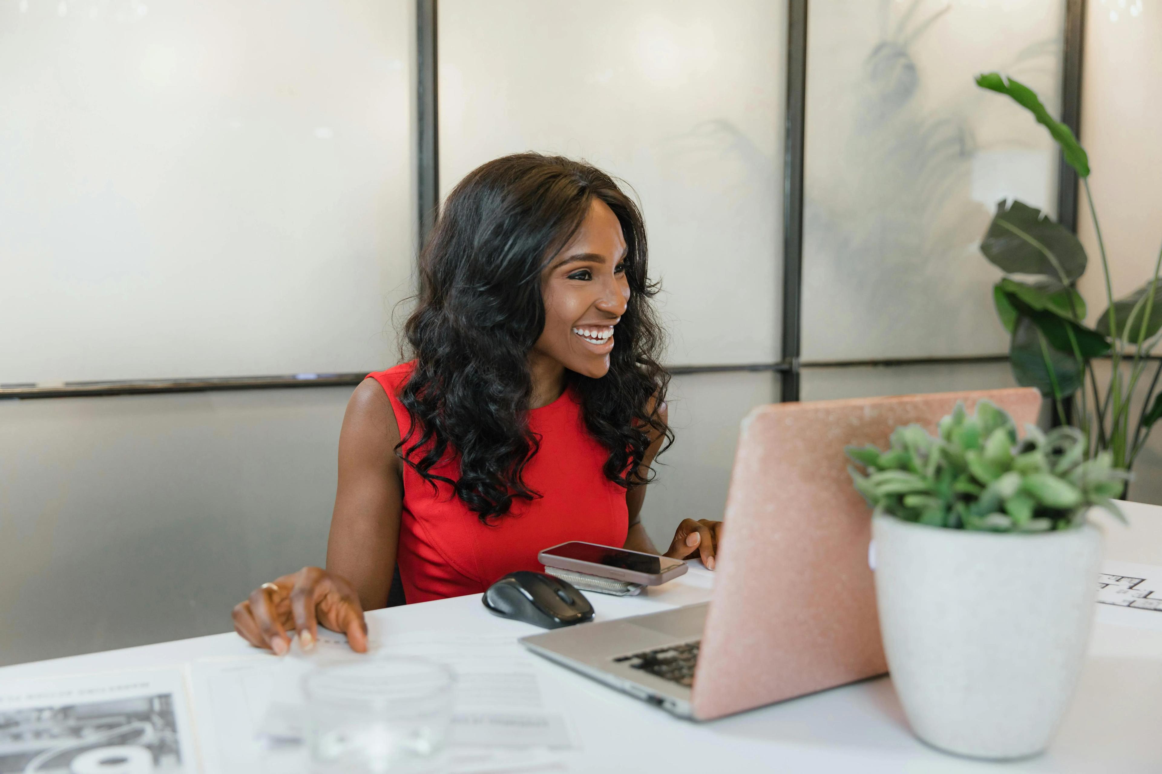 Small business consultant in a red dress working on digital marketing strategies to boost small business growth.