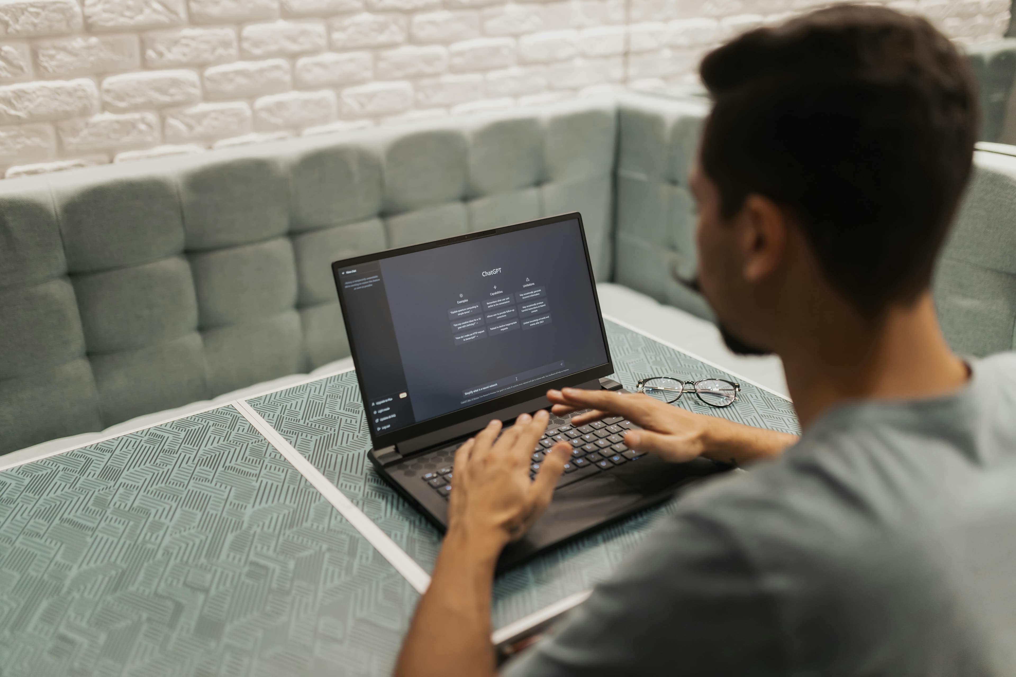  A focused individual working on a laptop in a modern workspace, exploring how to create a free AI landing page to optimize web design and improve conversion rates.